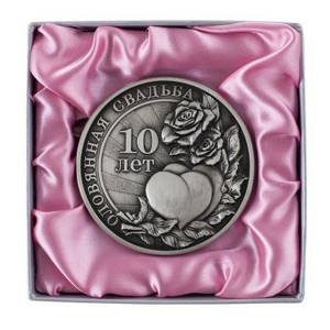 оловянная медаль на розовой подложке